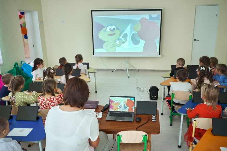Students watching Sesame Street inn a classroom.